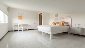 Une chambre à coucher comprenant un lit, une table de chevet, une chaise et un petit bureau.