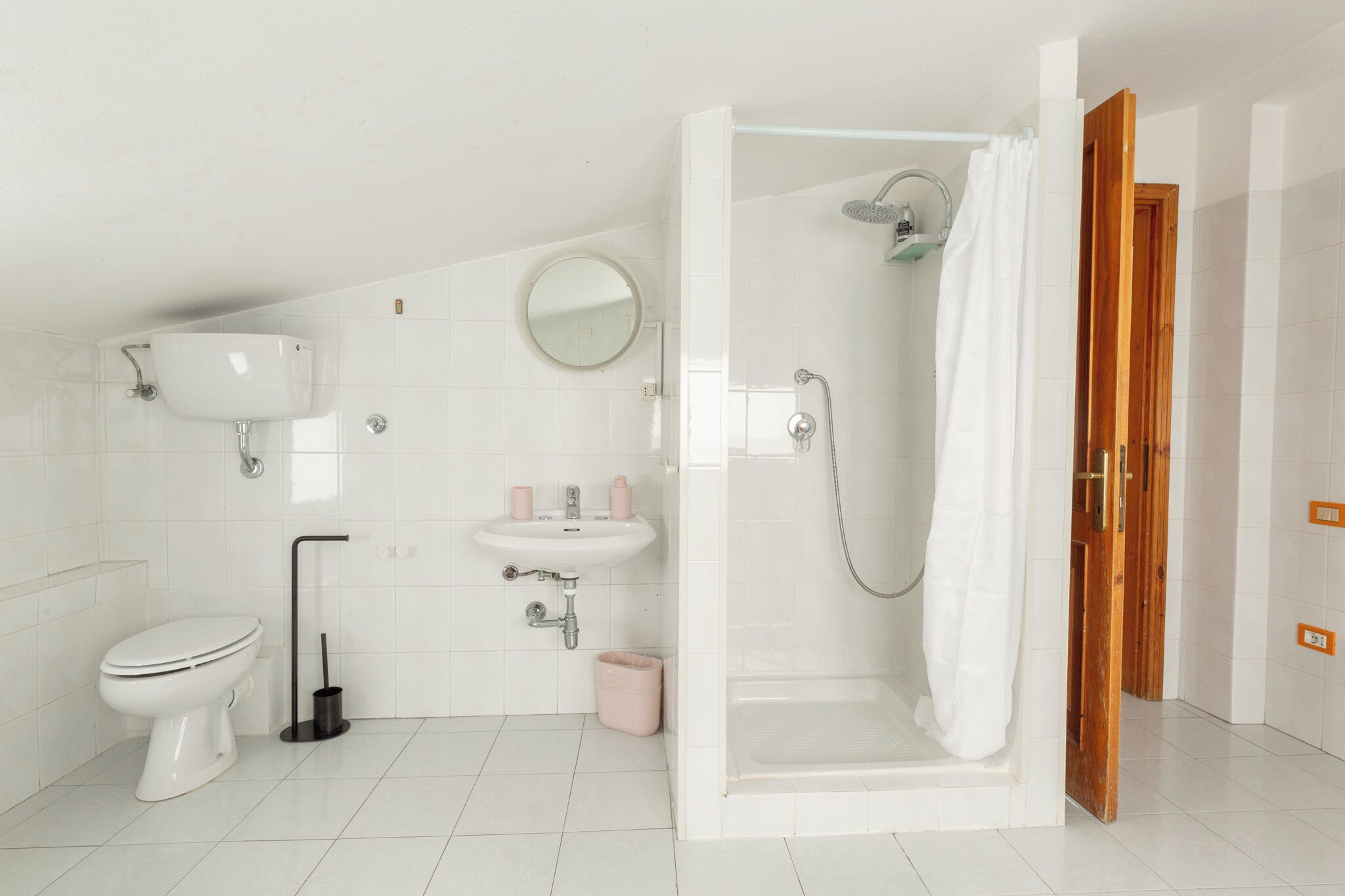 Een moderne badkamer met toilet, wastafel en douchehoek.