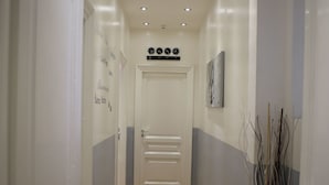 A hallway with wooden flooring, white walls, and recessed ceiling lights. - Blanco Vaticano (Rome)