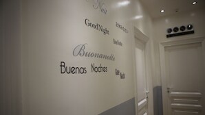 A hallway with a wall displaying multilingual 'Good Night' phrases. - Blanco Vaticano (Rome)