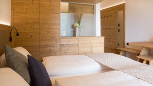Un dormitorio con cabecera de madera, una mesita de noche y un espejo.