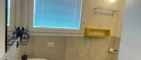 Un baño con lavamanos, inodoro y ventana.