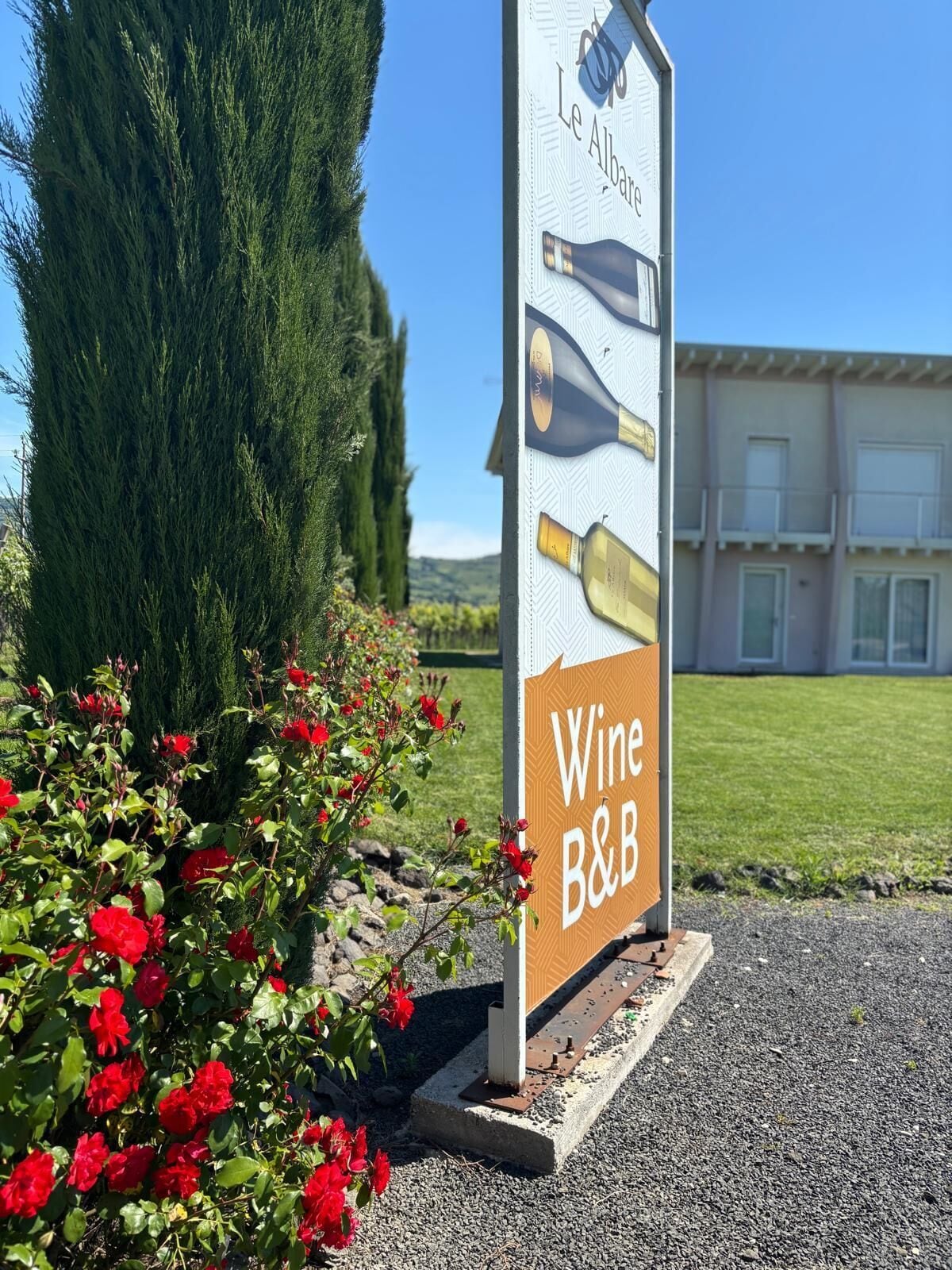 A sign for a wine and bistro with a building in the background.