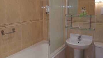 A bathroom with a bathtub, a glass-enclosed shower, a sink, and a toilet.