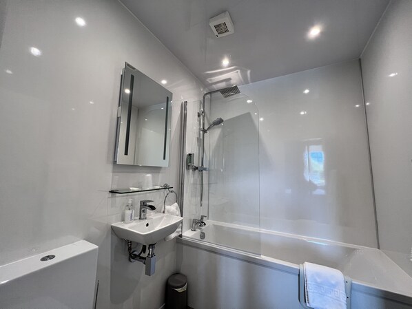 A modern bathroom with a glass shower enclosure, a sink with a mirror above, and a towel rack. - Ardshiel Hotel (Campbeltown)
