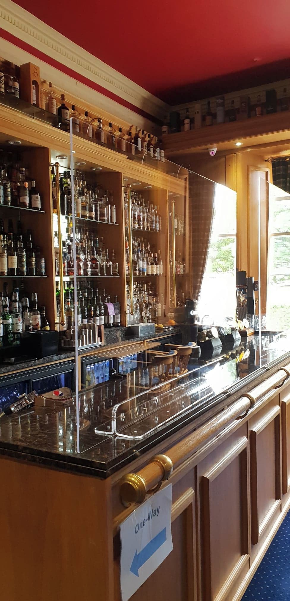 A bar area with a one-way sign, shelves with bottles, and a counter with a cash register.