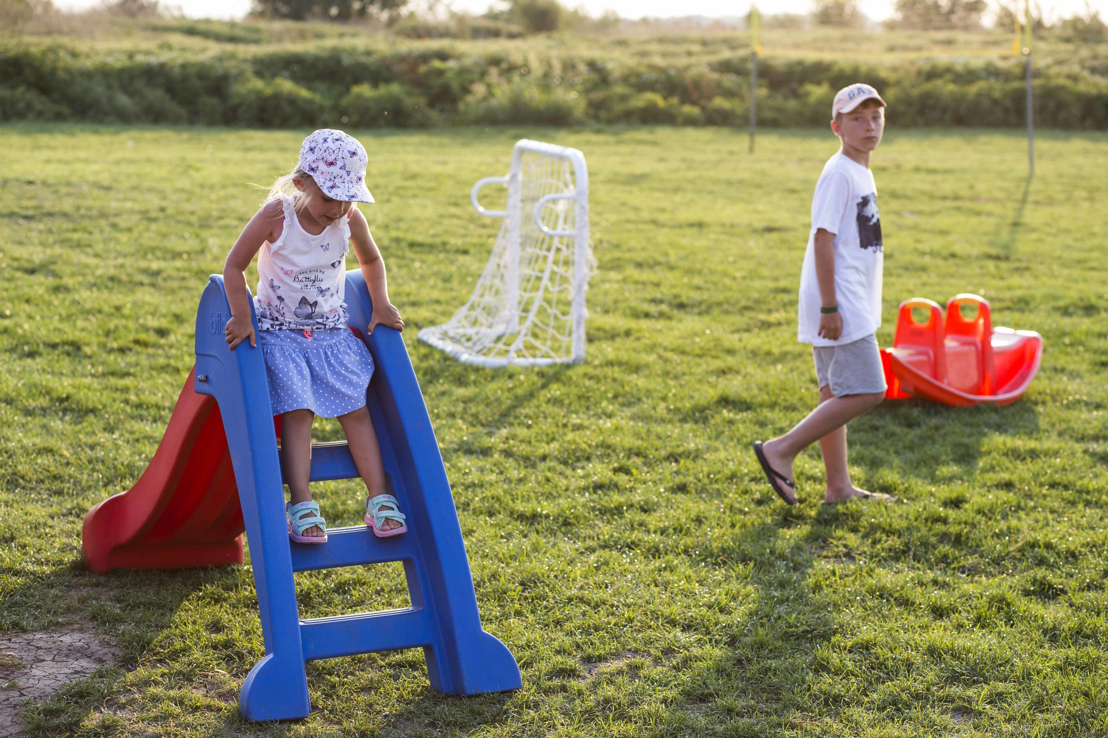 A playground with a blue slide and a white climbing structure.