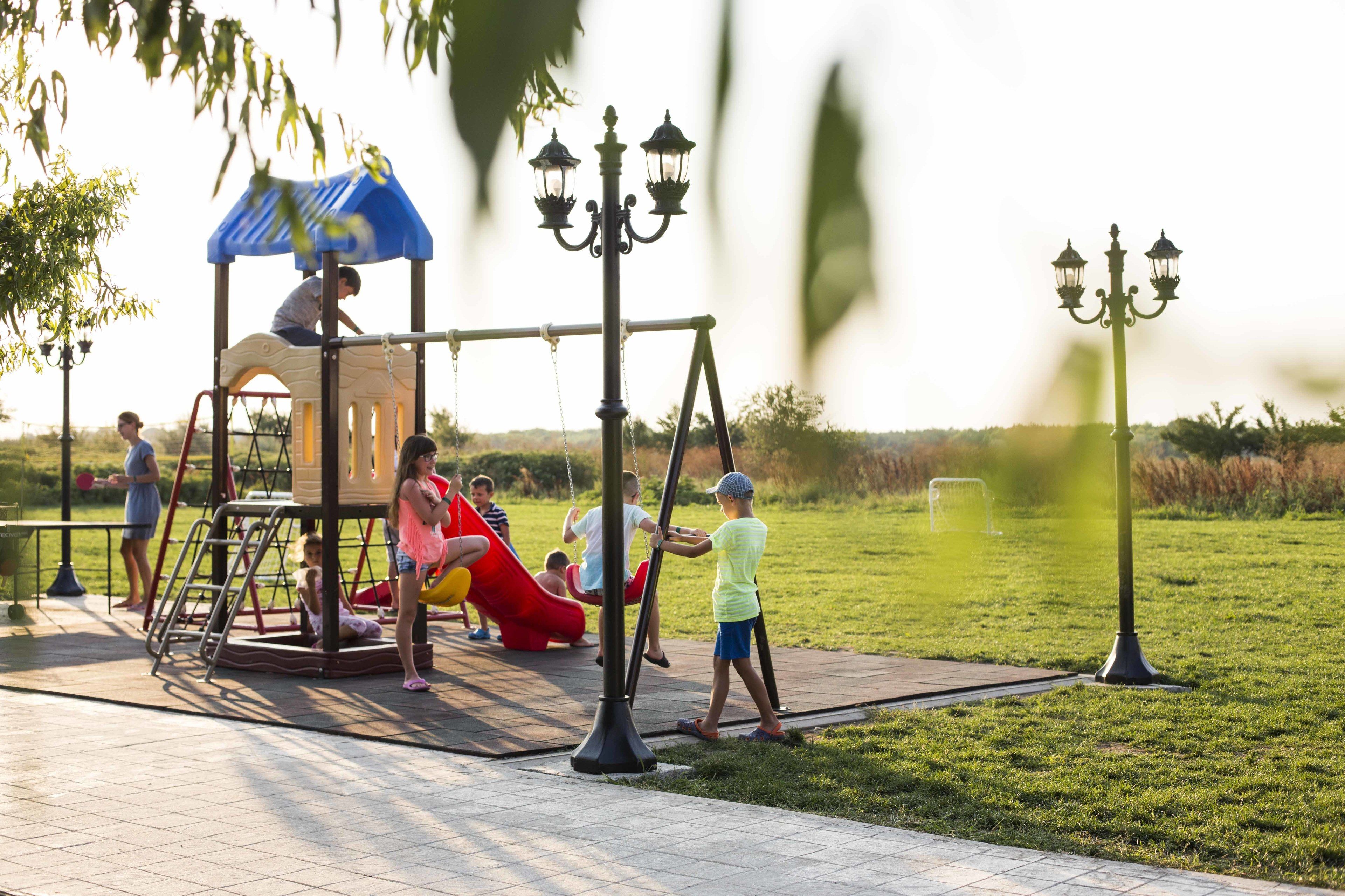 A playground with a swing set, a slide, and a climbing structure.