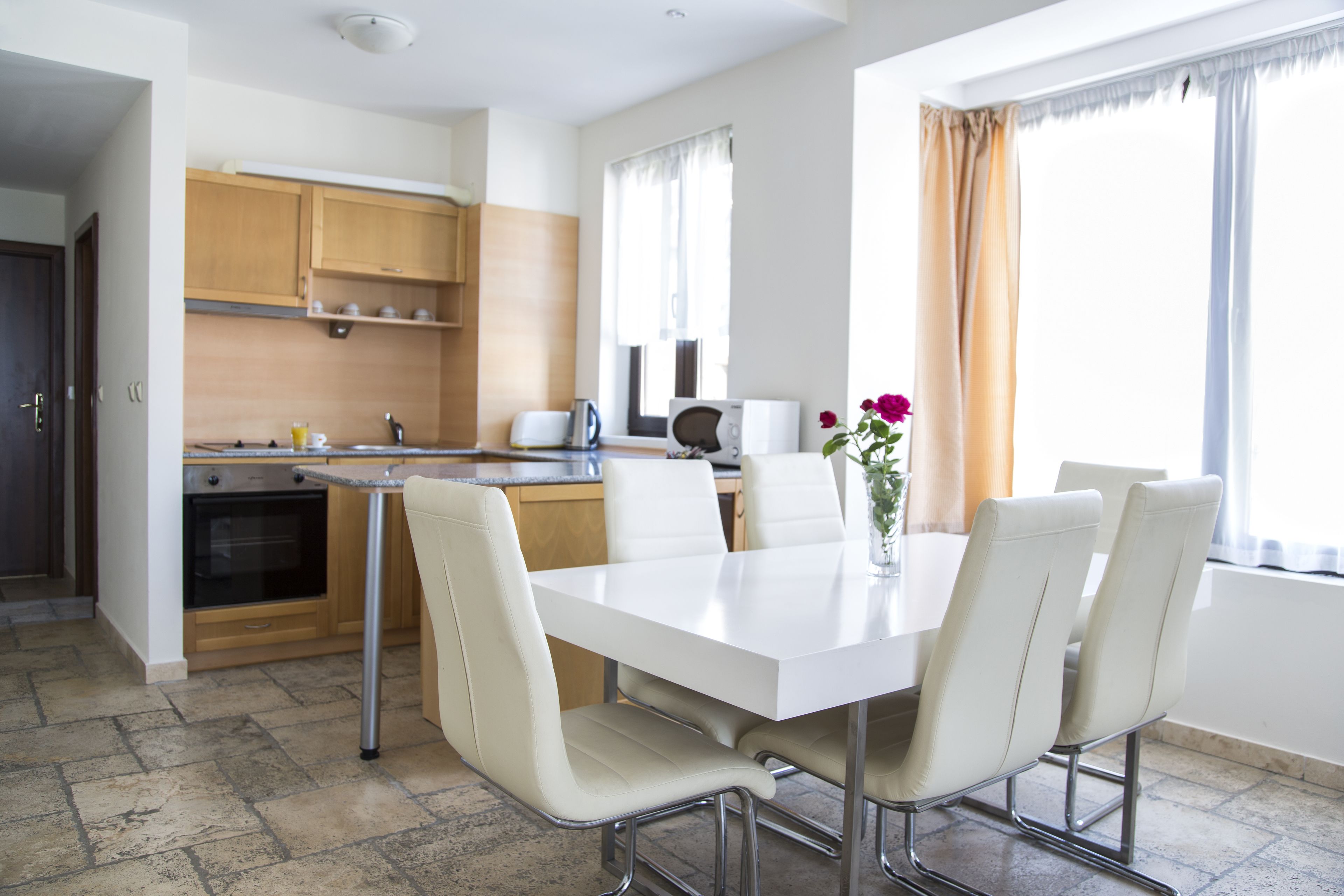 A modern kitchen with wooden cabinets, a white countertop, and a built-in oven.