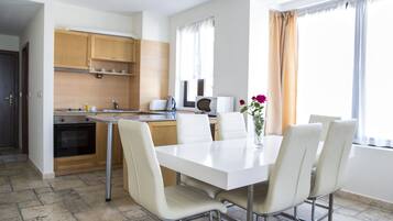A modern kitchen with wooden cabinets, a white countertop, and a built-in oven.