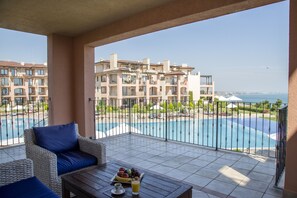 A balcony with a view of a swimming pool and a building in the background. - Kaliakria Resort (Kavarna)