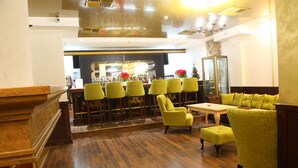 Een bar met meerdere stoelen en een balie.