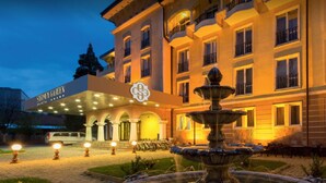 Een hotel met een fontein, een overdekte ingang en een bord met de tekst 'Stimson Garden'.