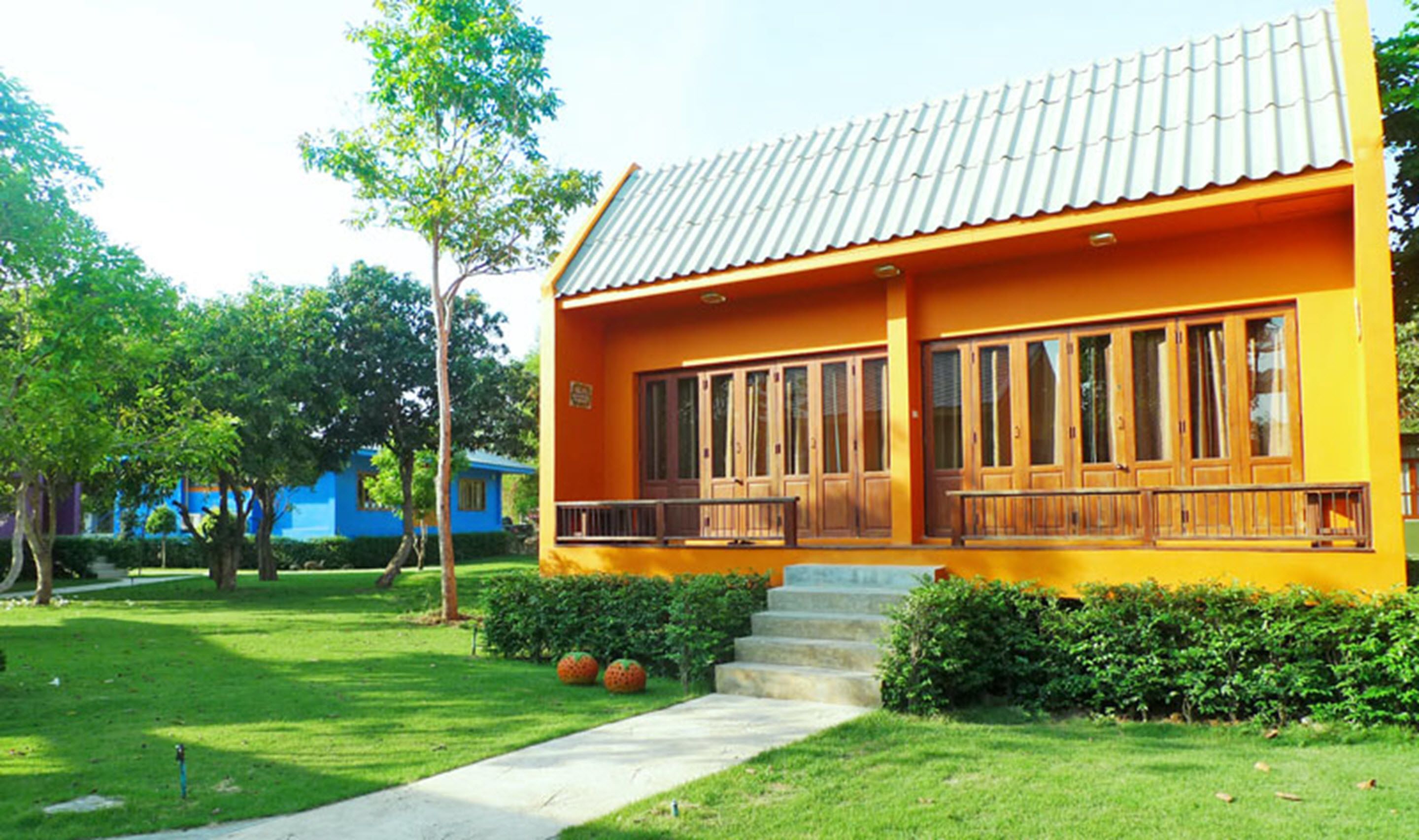 A two-story building with a tiled roof, large windows, and a balcony.