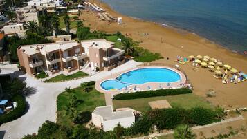 Ein Resort mit Schwimmbad, Strand und mehreren Gebäuden.