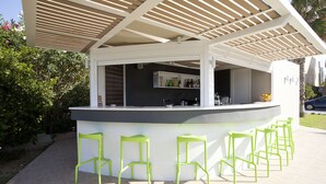 A bar area with a counter, bar stools, and a sheltered seating area. - Phaedra Hotel (Chania)