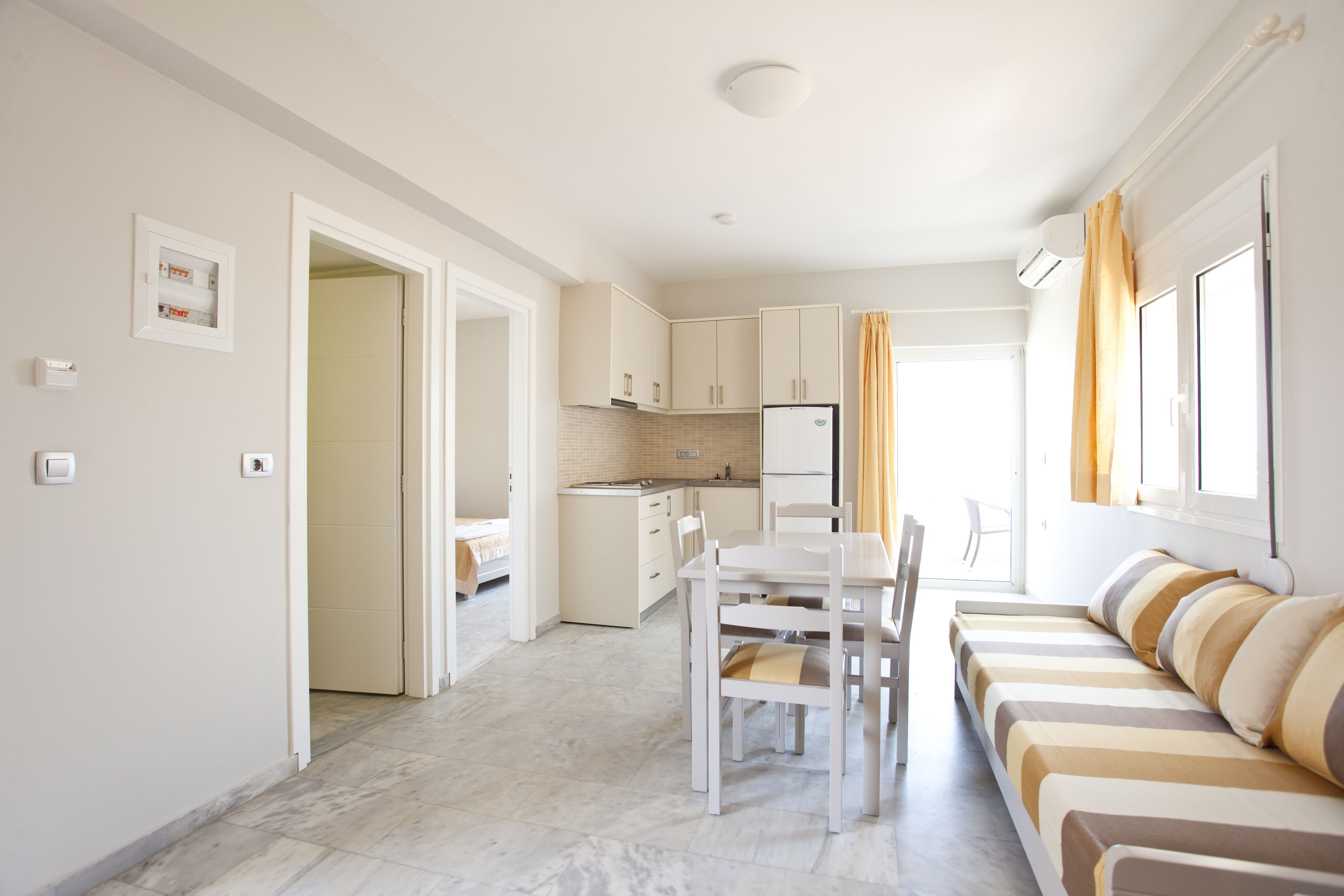 Un apartamento moderno y bien iluminado con cocina, comedor y sala de estar con sofá.