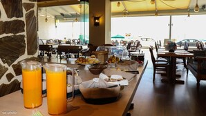 A breakfast buffet with orange juice, bread, and pastries. - Birais Beach Studios (Rethymno)