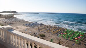 A beach with rows of umbrellas and sun loungers, a clear sky, and the ocean. - Birais Beach Studios (Rethymno)