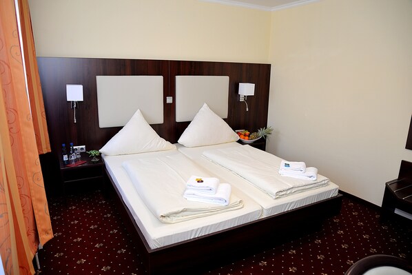 Relax in comfort with a large bed, a table for refreshments, and convenient wall-mounted lamps.