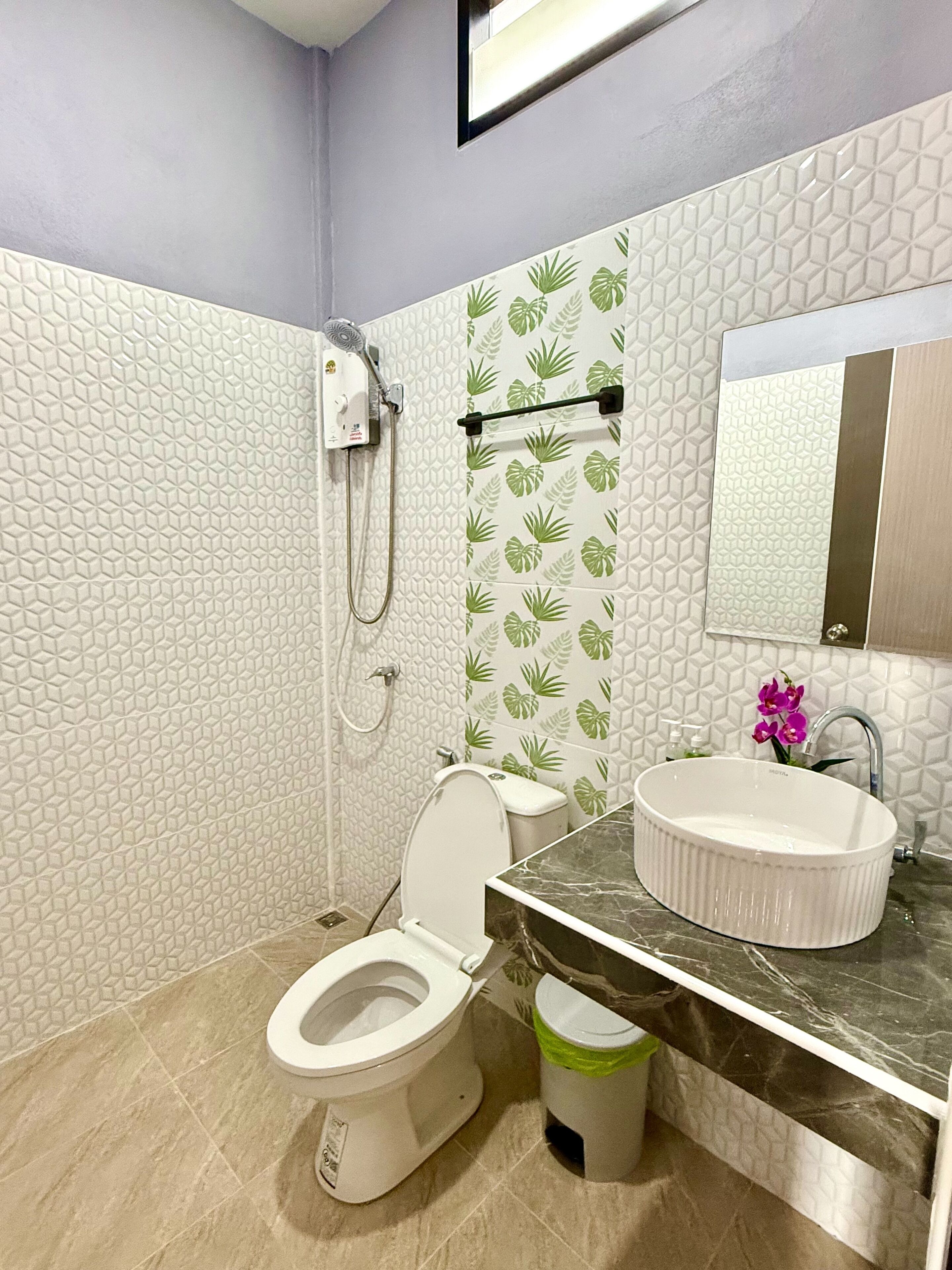 A bathroom with a toilet, sink, and shower.