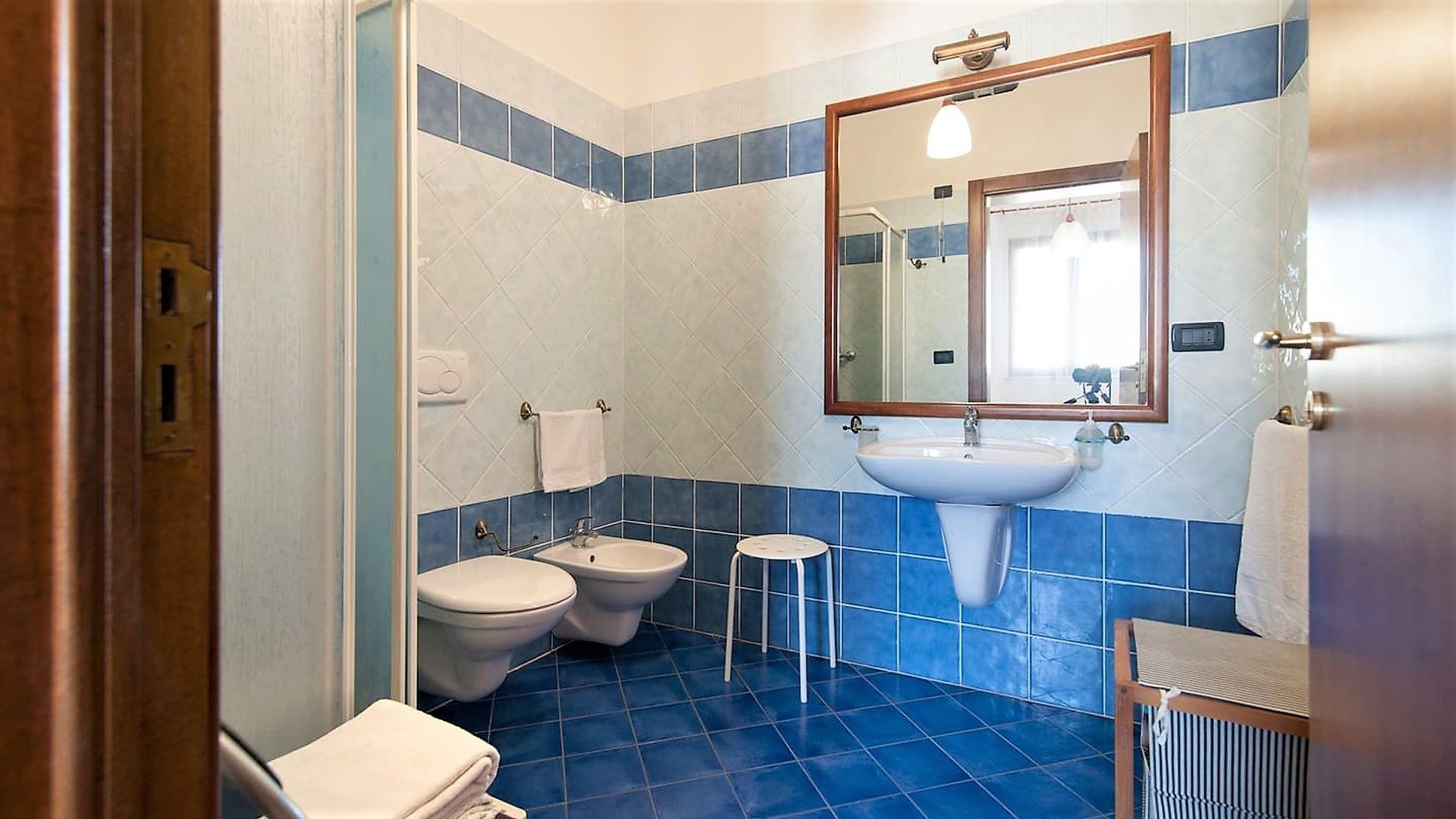 A bathroom with two toilets, a sink, and a mirror.