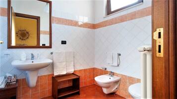 Un baño con lavamanos, bidé y espejo.