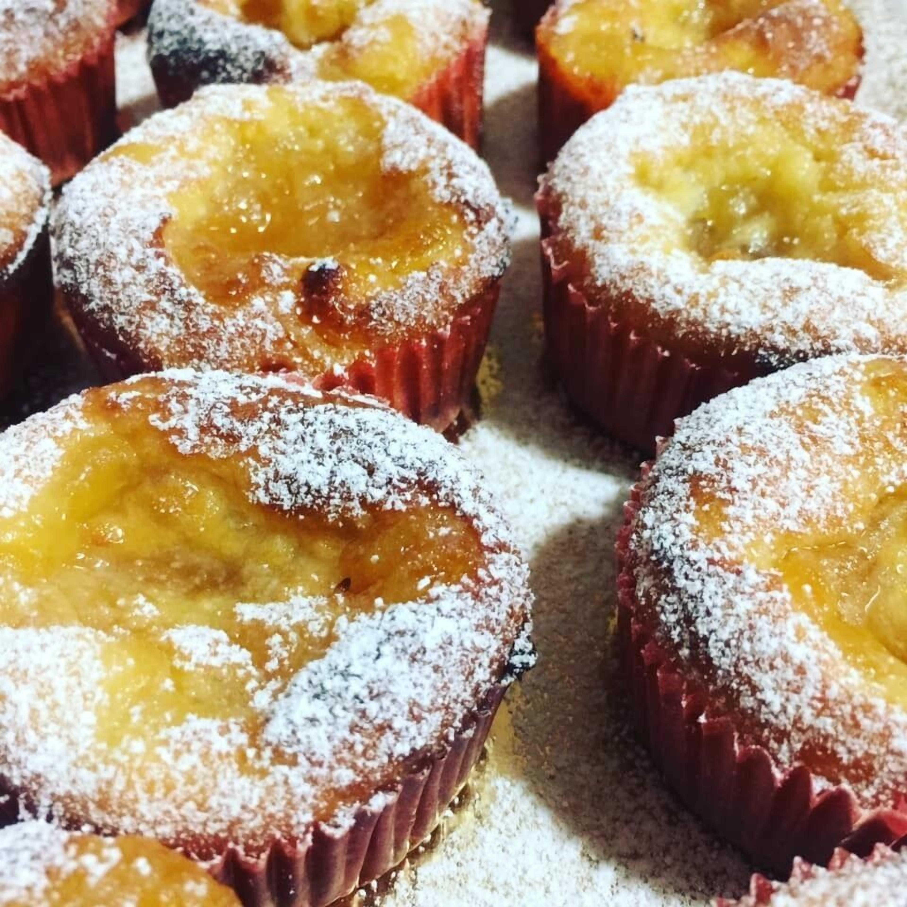 A close-up of several pastries dusted with powdered sugar.