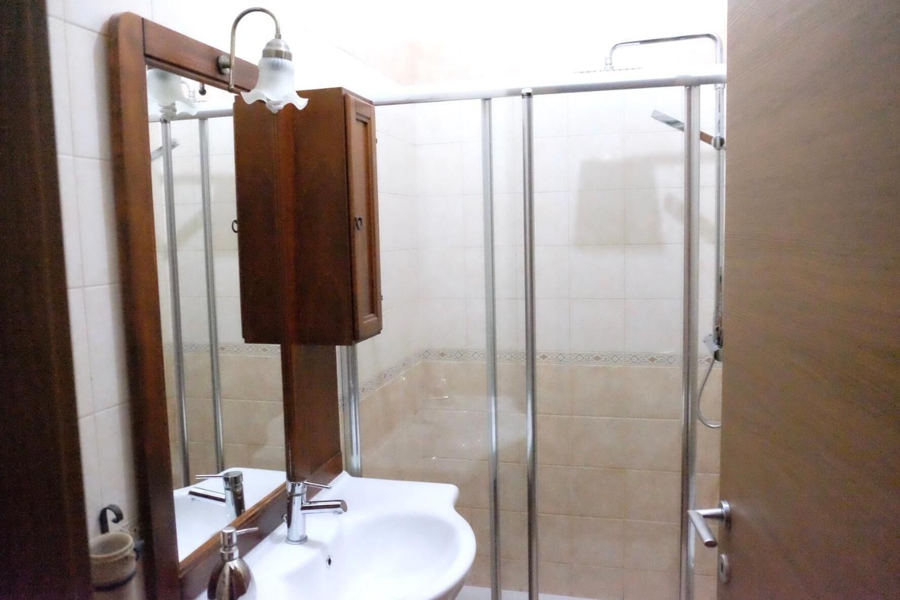 A bathroom with a shower, a sink, and a mirror.
