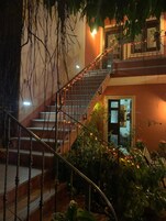 Una escalera con barandilla, rodeada de vegetación y luces de adorno.