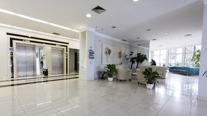 A spacious lobby with a modern design, featuring a reception area, seating, and a large window providing natural light. - Di Giulio Hotel (São José dos Campos)