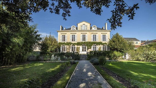A large, historic building with a symmetrical facade, a central entrance, and a well-maintained garden with a gravel path leading to the entrance. - La Maison de Maître (Fontenay-le-Comte)