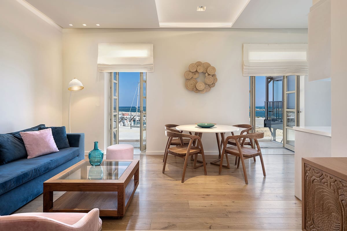 A modern living room with a sofa, coffee table, and dining area.