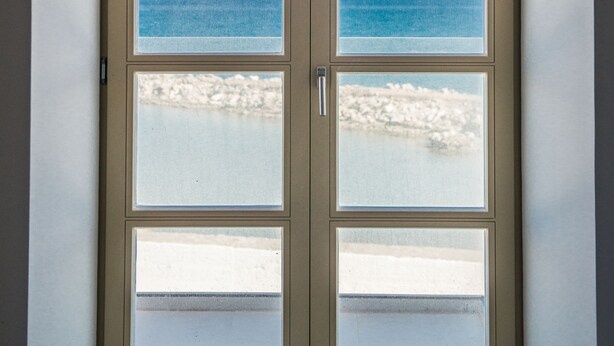 A door with multiple glass panels, each offering a view of the ocean and beach. - Avra Apartments Kolymbari Harbour (Platanias)