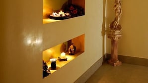 Um corredor com três prateleiras iluminadas contendo diversos objetos.
