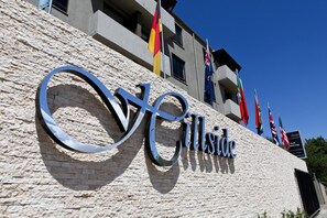 A hotel sign with the name "Cillside" and multiple flags. - Hillside Executive Accommodation (Windhoek)