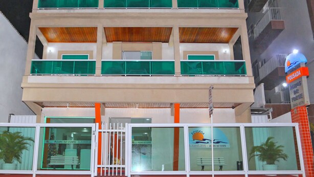A multi-story building with a flat roof, large windows, and a sign indicating it is a hotel. - Pousada Águas do Forte (Cabo Frio)