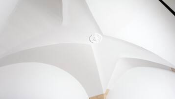 A modern interior with curved white walls and a central decorative element.