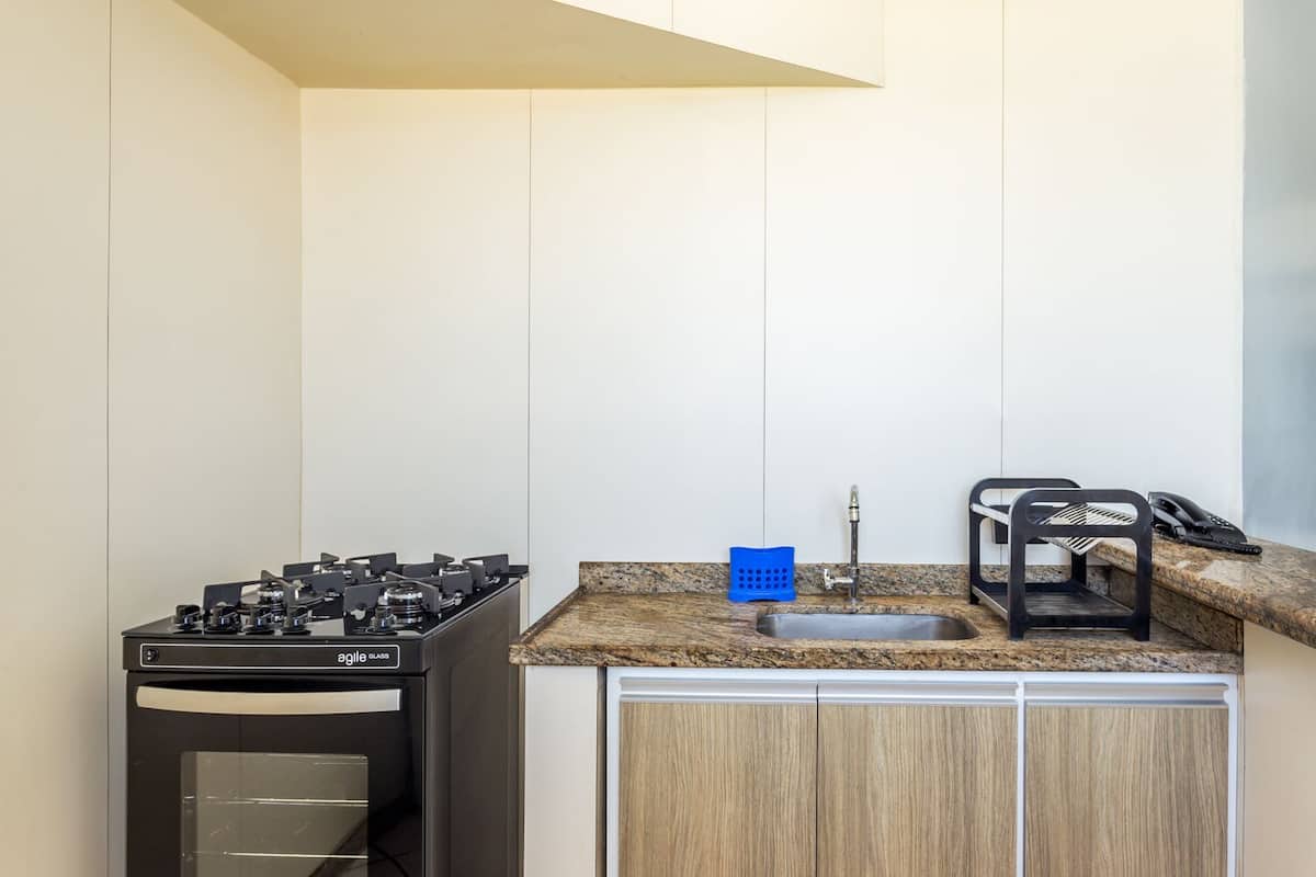 A compact kitchen with a gas stove, a sink, and a countertop.