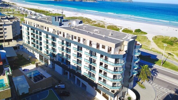 Ein mehrstöckiges Hotel mit Balkonen mit Blick auf Strand und Meer.