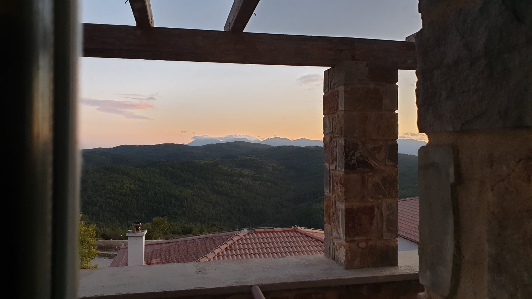 A view from a building's interior, overlooking a mountainous landscape with a clear sky.