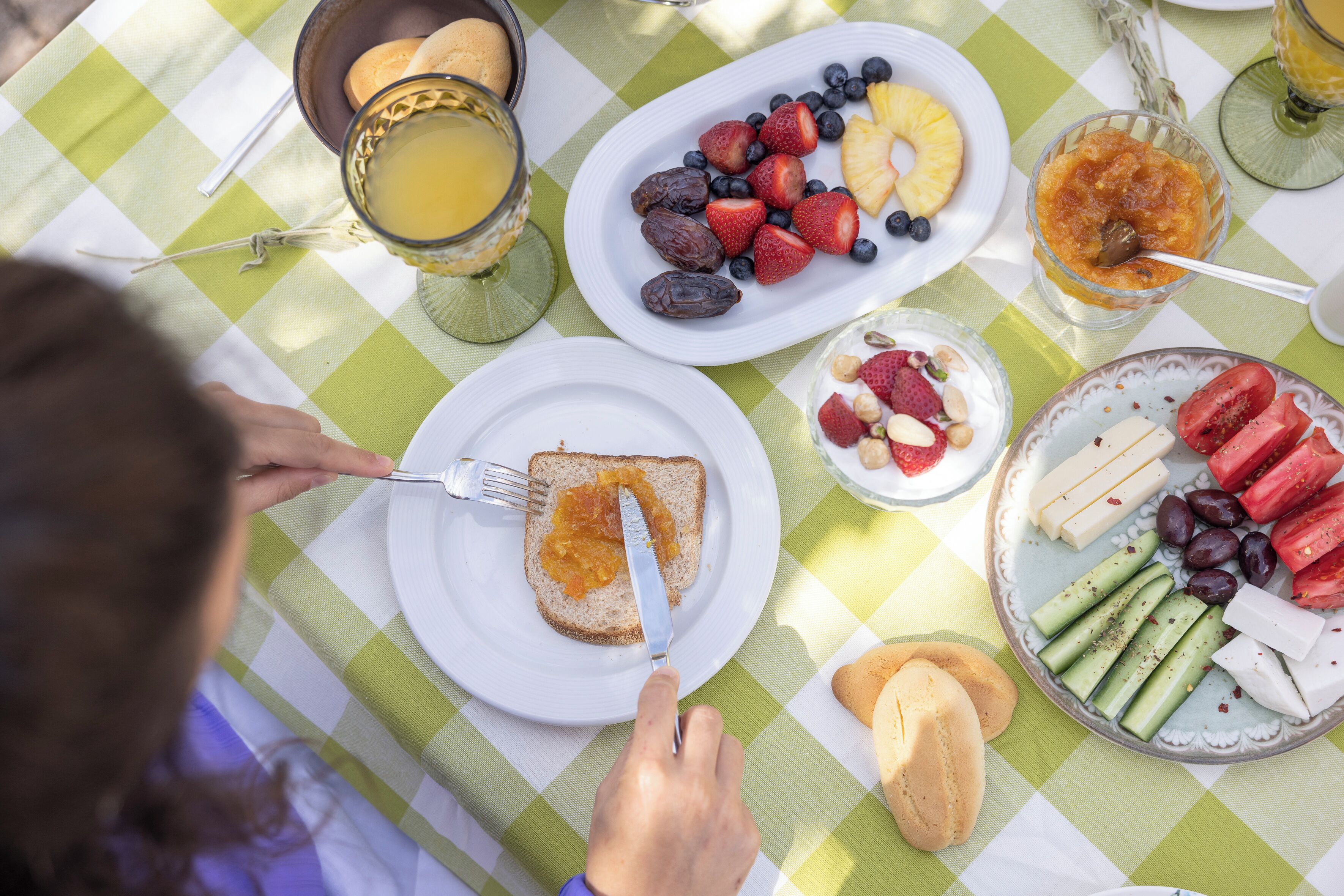 A table with breakfast items including toast, fruits, and beverages.