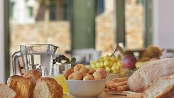 Uma mesa com pão, uvas e um jarro de suco.