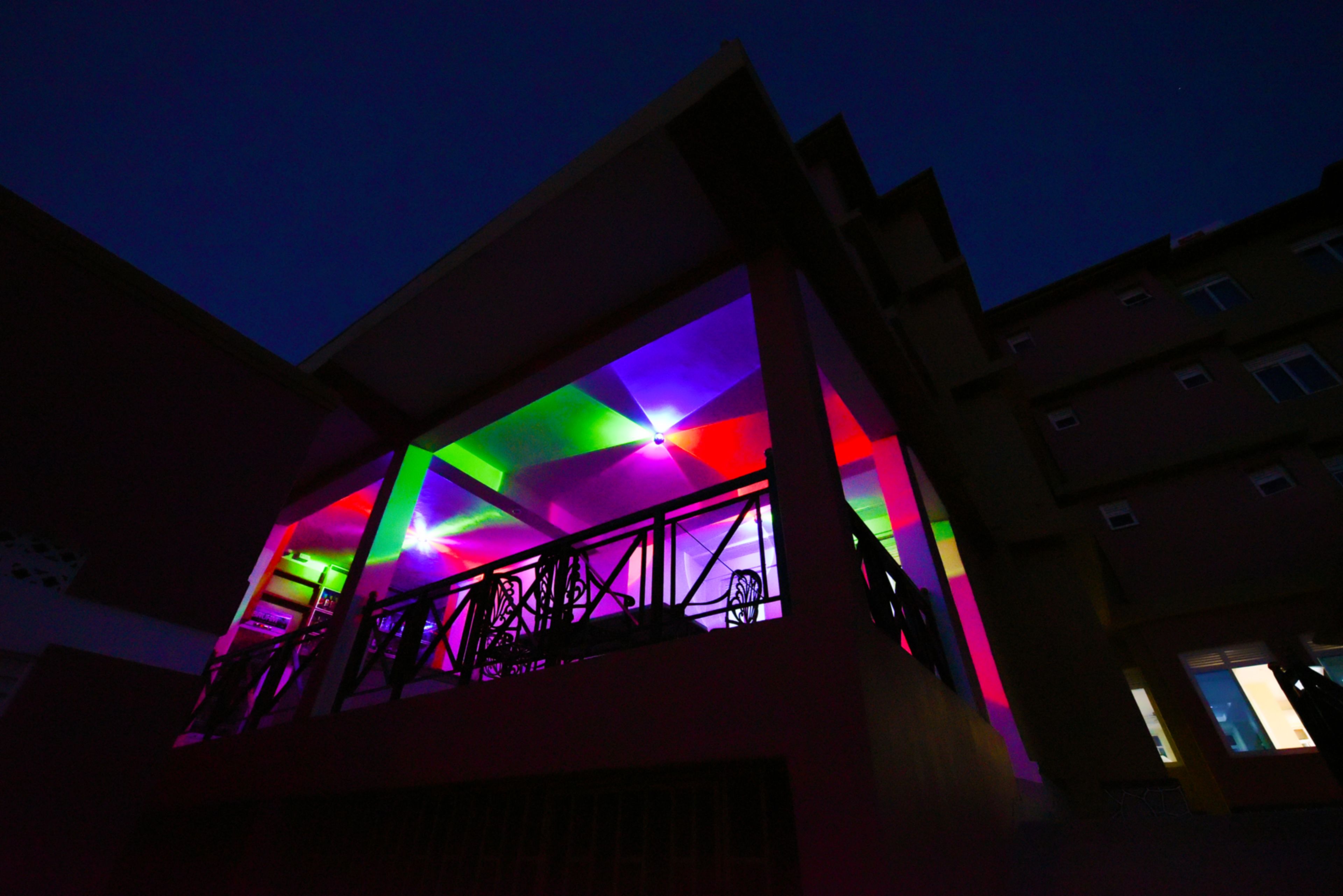 A building with a balcony and a colorful light display.