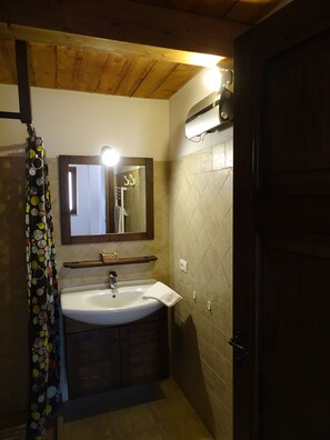 A bathroom with a wooden ceiling, a white sink, a mirror, and a shower curtain. - Agriturismo Podere 1248 (Ladispoli)