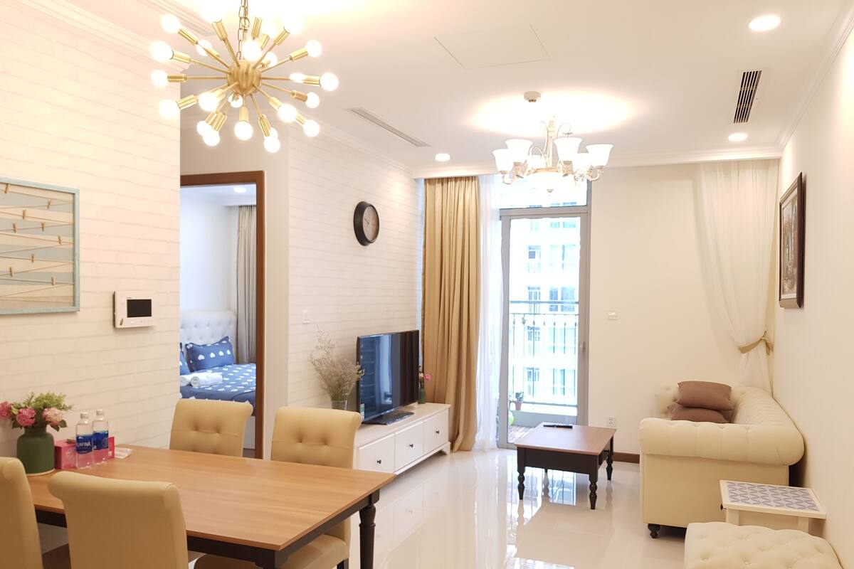 A modern living room with a dining area, a TV, and a balcony view.