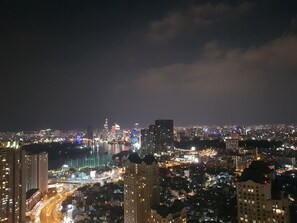 A nighttime cityscape with illuminated buildings and a busy road. - The Berry Vinhomes Luxury Apartments (Ho Chi Minh City)