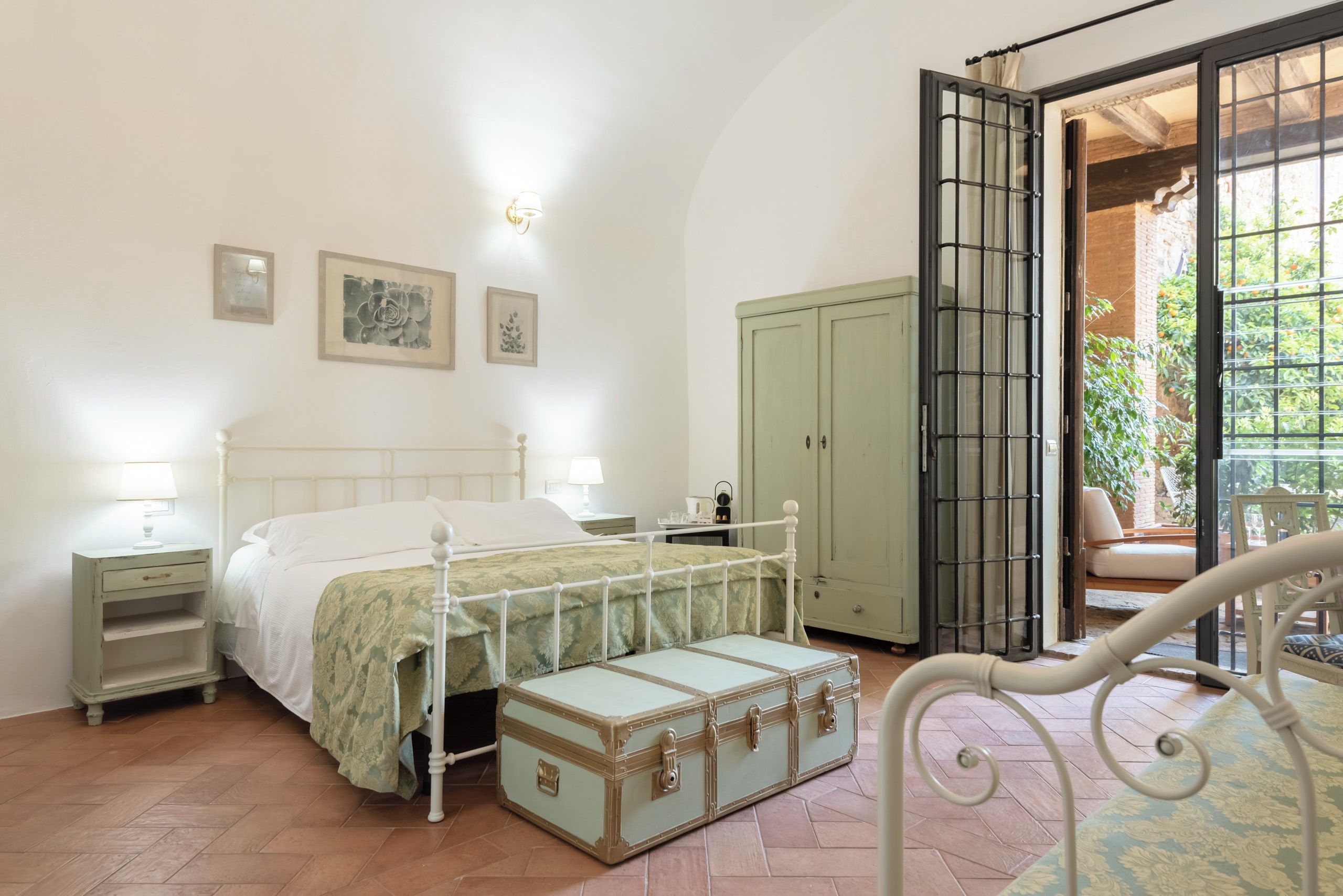 Un dormitorio con cama, mesitas de noche, un armario y una maleta.