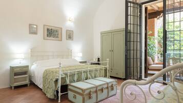 Un dormitorio con cama, mesitas de noche, un armario y una maleta.