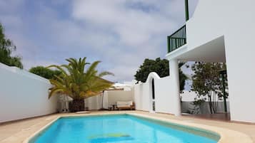 Una piscina al aire libre, tumbonas